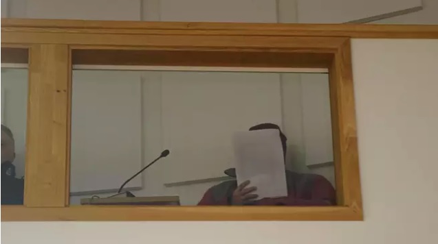 Syytetty eristettiin asianosaisista istuntosalin parvelle. Hän peitti kasvonsa. Kuva: Mirja Rintala