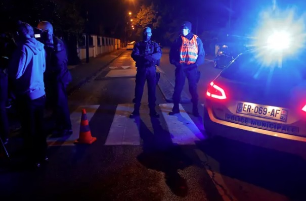 Poliisi eristi hyökkäyspaikkaa Conflans Saint-Honorinen lähiössä Pariisissa perjantaina.­KUVA: CHARLES PLATIAU / REUTERS