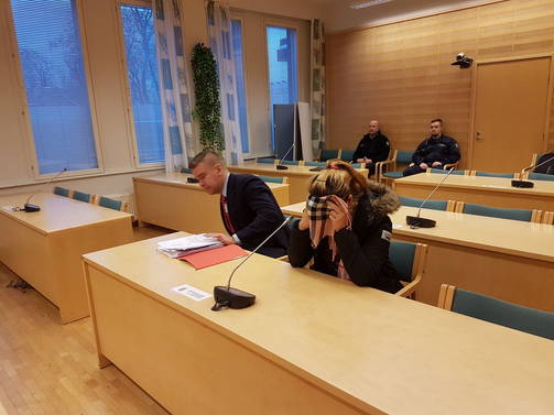 Syytetty nainen peitti kasvonsa kameroilta käräjäoikeuden salissa. (KARI KAUPPINEN)
