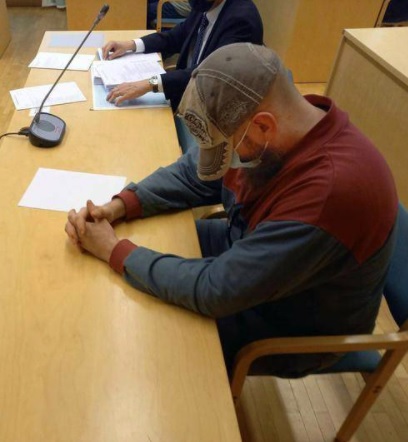 Murhasta syytetty saapui käräjäsaliin lippalakkiin ja kasvomaskiin sonnustautuneena. KUVA: JANNE KETTUNEN