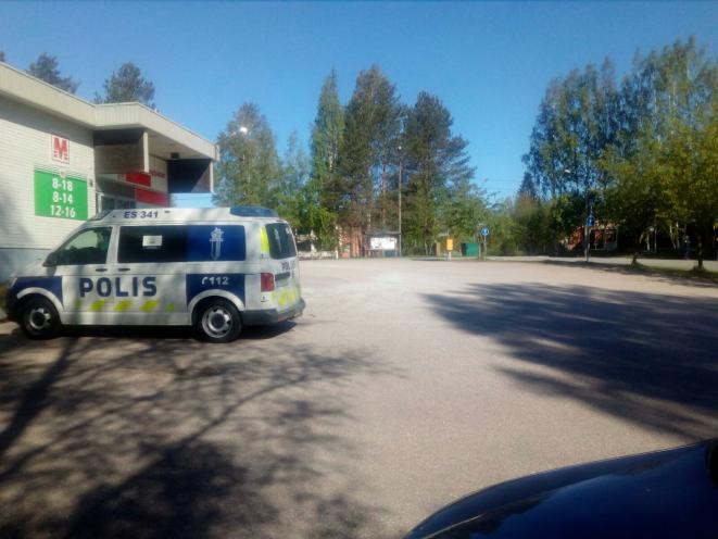 Aseistautunut poliisi valvoo liikennettä Mäntyharjun Kauppatiellä.