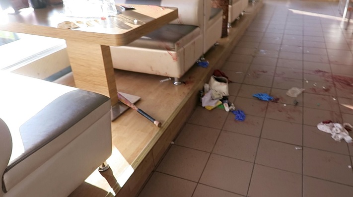 Tältä näytti pizzeriassa tapahtumien jälkeen. Kuvassa naisen laukku sekä pöydän alle pudonnut pesäpallomaila. POLIISIN ESITUTKINTAMATERIAALI