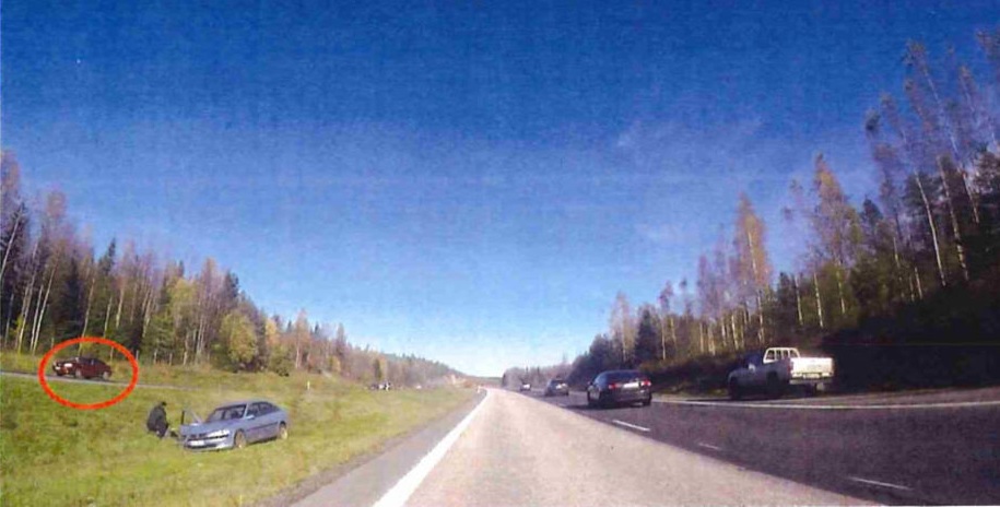Kuvakaappaus moottoripyöräpoliisin Go Pro -kamerasta. Poliisi näki auton keskiviheriöllä ja sen etukulmassa miehen. Poliisi päätti mennä selvittämään mistä oli kyse. Rengastettuna todistajan auto. (POLIISI)