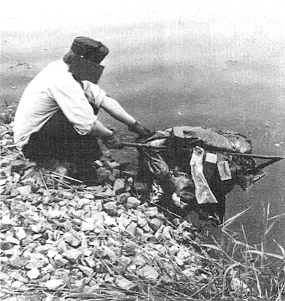 Kääröä nostetaan maihin. Kuvassa näkyvissä metalliputki ja viisi harkkotiiltä.jpg