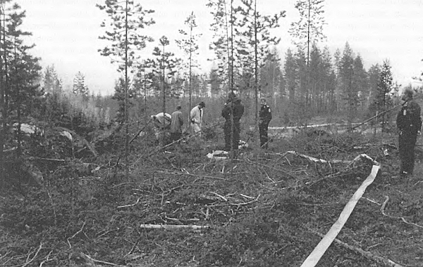 Kolme siviiliasuista poliisia tutkii Pia Ristikareen ruumiin löytöpaikkaa.jpg