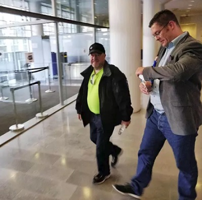 Ilja Janitskin poistui Helsingin käräjäoikeudesta heti vapauttamispäätöksen jälkeen. Hän sai oikeustalon aulassa tukijaltaan viinapullon. (KUVA: LASSE KERKELÄ / HS)