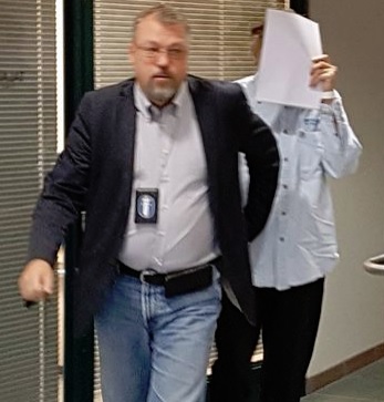 Lähisukulaisensa murhasta epäilty 51-vuotias mies peitti kasvonsa poistuessaan oikeussalista. JUHA VELI JOKINEN