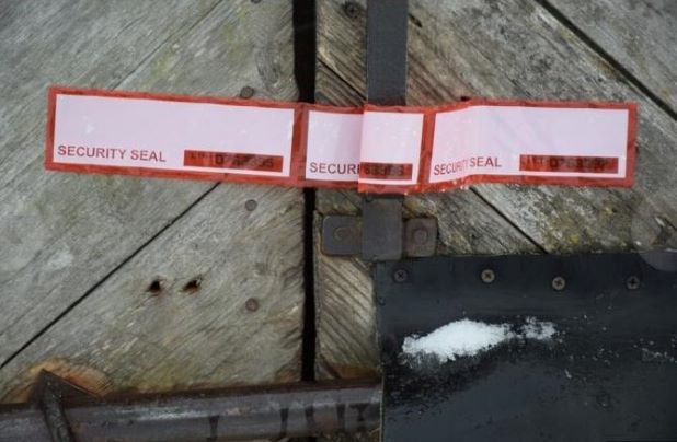 Kokaiinin logistiikkakeskuksena toimineen entisen sikalan ovi on nyt suljettu viranomaisten sinetillä.jpg
