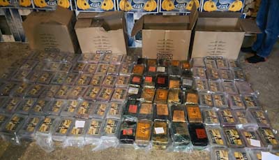 Kilon painoisia kokaiinipaketteja leviteltynä halkopajan lattialle.jpg