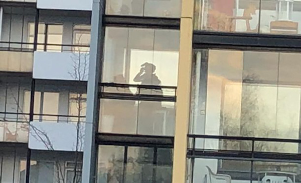 Erikoisvarusteinen poliisi tutki asunnon parveketta.jpg