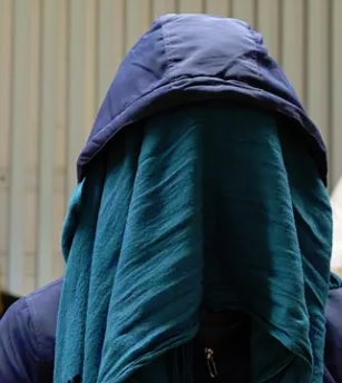 Syytetty mies peitti kasvonsa kaulaliinalla, kun käräjäoikeus aloitti jutun käsittelyn. (KUVA: VILLE HONKONEN)