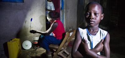 Ugandalainen nainen valmistaa perheelleen iltaruokaa LED-valon avulla.jpg