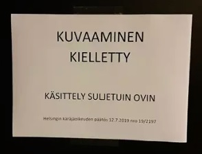 Kuvauskiellosta ja asian käsittelystä suljetuin ovin ilmoitettiin istuntosalin oveen kiinnitetyllä lapulla. (KUVA: JUHO JOKINEN / HS)