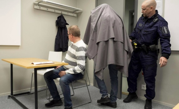 Syytetty saapui poliisitalon istuntosaliin verhoutuneena lakanaan. (KUVA: JUHA TANHUA).