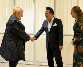 Halonen nöyristelemässä kahden, sittemmin rikoksista epäillyn edessä. Paljonkohan tuli tällä kertaa luvattua avustuksia?